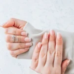 French classic manicure female fingers with beautiful nails white background